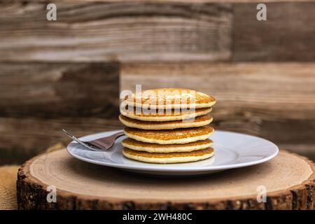 Une grande pile de crêpes avec une fourchette contre un fond de bois sans sirop Banque D'Images