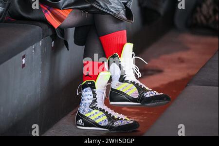 Berlin, Allemagne. 06th Feb, 2024. Un invité arrive à l'exposition de l'étiquette Dzhus portant des bottes de boxer à la mode et des chaussettes rouges. Crédit : Jens Kalaene/dpa/Alamy Live News Banque D'Images