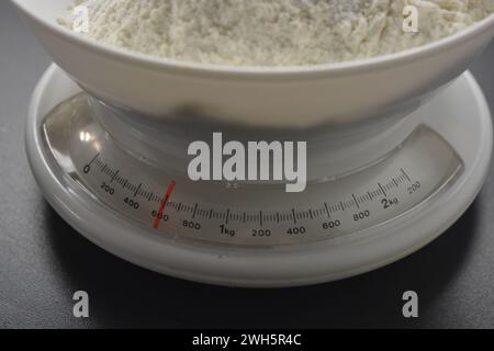 Des poids blancs faits maison, sur table, avec de la farine de blé sont situés sur le comptoir gris de la cuisine. Banque D'Images