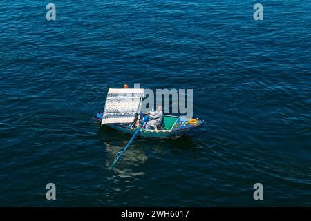 Les vendeurs de textiles sur leurs bateaux approchent un bateau de croisière en attendant d'entrer dans l'écluse d'Esna. Les vendeurs espèrent vendre des marchandises aux touristes. Esna, Égypte – octobre 20 Banque D'Images