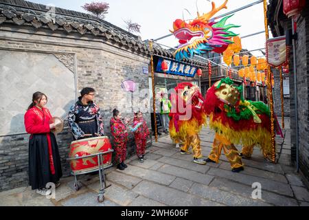 Xingyi, Chine. 08th Feb, 2024. Les enfants regardent un lion danser dans la zone de tourisme culturel et de loisirs Baziqiao de la rue Zhaoyang à Xinghua, en Chine, le 8 février 2024. (Photo de Costfoto/NurPhoto) crédit : NurPhoto SRL/Alamy Live News Banque D'Images