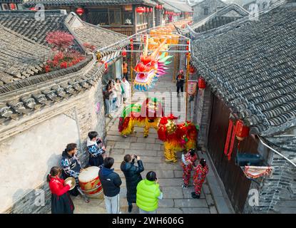 Xingyi, Chine. 08th Feb, 2024. Les touristes regardent un spectacle de danse du lion au quartier de loisirs Baziqiao Cultural Tourism de la rue Zhaoyang à Xinghua, en Chine, le 8 février 2024. (Photo de Costfoto/NurPhoto) crédit : NurPhoto SRL/Alamy Live News Banque D'Images