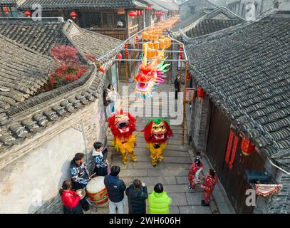 Xingyi, Chine. 08th Feb, 2024. Les touristes regardent un spectacle de danse du lion au quartier de loisirs Baziqiao Cultural Tourism de la rue Zhaoyang à Xinghua, en Chine, le 8 février 2024. (Photo de Costfoto/NurPhoto) crédit : NurPhoto SRL/Alamy Live News Banque D'Images