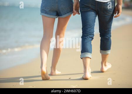 couple tenant la main laissant des empreintes de pas sur la plage Banque D'Images