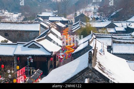 Suqian, Chine. 08th Feb, 2024. Une lanterne dragon géante se distingue du paysage enneigé et des bâtiments anciens sur la rue Huangpai dans le comté de Xuyi de la ville de Huai'an, à Suqian, en Chine, le 7 février 2024. Les touristes prennent des photos et découvrent la saveur du nouvel an lunaire. (Photo de Costfoto/NurPhoto) crédit : NurPhoto SRL/Alamy Live News Banque D'Images