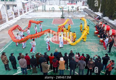 Suqian, Chine. 08th Feb, 2024. Deux équipes de danse du dragon se produisent pour les villageois pour accueillir le nouvel an lunaire sur la place du village Zhongtong à Suqian, dans la province du Jiangsu, en Chine, le 7 février 2024. (Photo de Costfoto/NurPhoto) crédit : NurPhoto SRL/Alamy Live News Banque D'Images