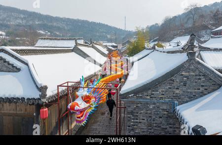 Suqian, Chine. 08th Feb, 2024. Une lanterne dragon géante se distingue du paysage enneigé et des bâtiments anciens sur la rue Huangpai dans le comté de Xuyi de la ville de Huai'an, à Suqian, en Chine, le 7 février 2024. Les touristes prennent des photos et découvrent la saveur du nouvel an lunaire. (Photo de Costfoto/NurPhoto) crédit : NurPhoto SRL/Alamy Live News Banque D'Images
