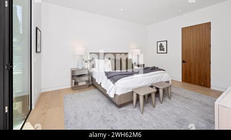 Une chambre confortable avec un lit confortable et des panneaux de verre Banque D'Images