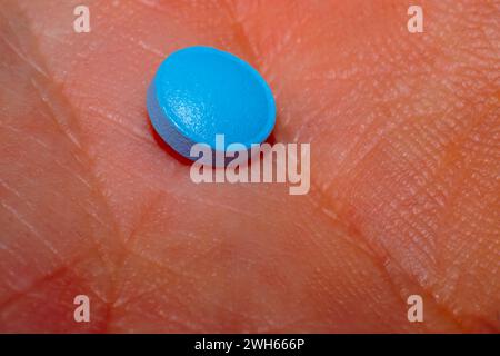 Une macro-photo en gros plan capturant les détails complexes d'une pilule bleue, représentant les soins pharmaceutiques pour la santé et le bien-être Banque D'Images