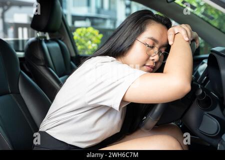 Jeune femme asiatique dormant en voiture. Banque D'Images