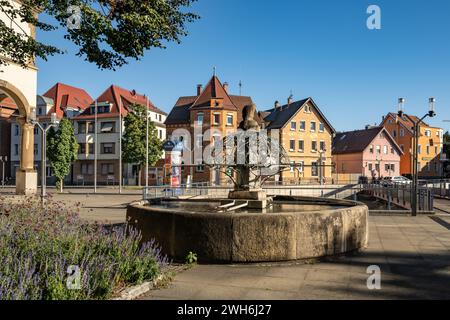 Fontaine en face de la mairie de Feuerbach - Blcik sur la fontaine et les maisons à la place de la mairie dans le soleil du soir. Banque D'Images