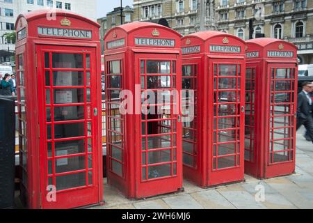Une rangée de quatre cabines téléphoniques rouges sur le Strand à Charing Cross, Londres, Angleterre Banque D'Images