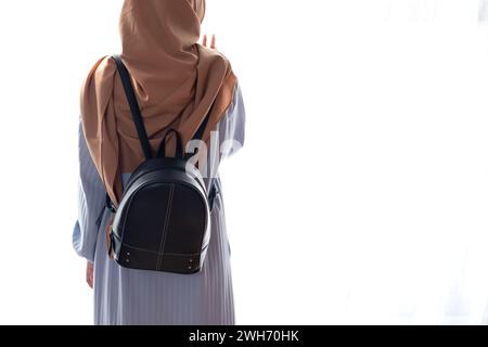 Femme musulmane debout avec sac à bandoulière sur fond blanc. Concept de voyage Banque D'Images