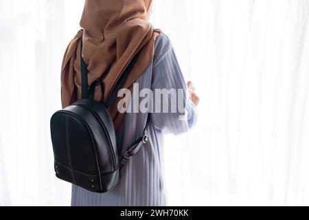 Femme musulmane debout avec sac à bandoulière sur fond blanc. Concept de voyage Banque D'Images