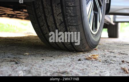 Le fond et les roues d'une voiture sur un sol sablonneux photo stock détaillée Banque D'Images