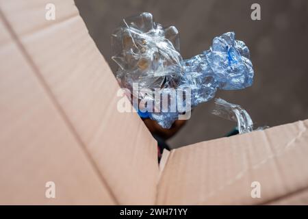 Recueillir les bouteilles en plastique usagées qui peuvent être recyclées dans des boîtes en carton Banque D'Images