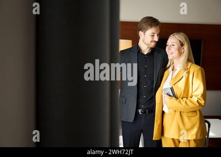 Couple voyageur debout à la fenêtre dans la chambre d'hôtel Banque D'Images