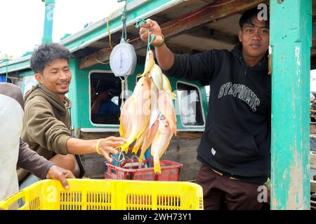 Lampung, Indonésie, 07 octobre 2022 : un homme indonésien tient un cintre sur un bateau de pêche à Lampung, en Indonésie. Banque D'Images