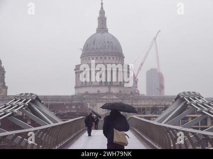 Londres, Royaume-Uni. 8 février 2024. Les gens traversent le Millennium Bridge alors que la pluie frappe la capitale. Crédit : Vuk Valcic/Alamy Banque D'Images