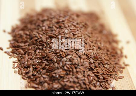 Les graines de lin brutes reposent sur une surface en bois dans la cuisine, préparées pour la cuisson. Vue de dessus. Effectuer la mise au point au centre des grains Banque D'Images