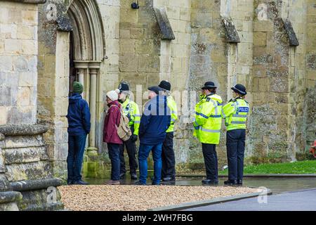 Des policiers vêtus de vestes jaunes interagissant avec des membres du public pendant une patrouille de sécurité à la cathédrale de Salisbury, Banque D'Images