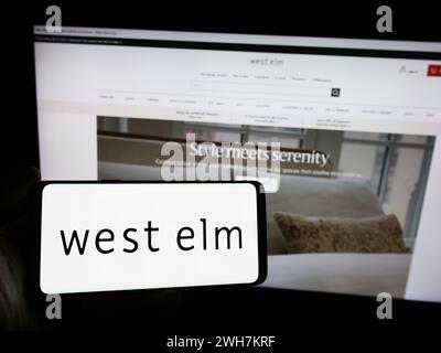 Personne tenant le smartphone avec le logo de la société de décoration d'intérieur West Elm en face du site Web. Concentrez-vous sur l'affichage du téléphone. Banque D'Images