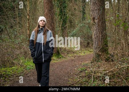 Une jeune femme marchant le long d'un sentier dans une forêt sereine Banque D'Images