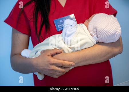 Brême, Allemagne. 08th Feb, 2024. Une sage-femme tient un bébé dans ses bras. Brême veut améliorer les conditions de travail des infirmières et des sages-femmes avec un projet pilote dans un hôpital. Le 'je m'allaite à nouveau parce que.' Le projet a été lancé à réussis Hôpital Joseph-Stift de Brême début février. Au cours des quatre prochaines années, l'objectif est de travailler avec les infirmières et les sages-femmes pour améliorer les conditions de travail dans la salle d'accouchement et la maternité. Crédit : Sina Schuldt/dpa/Alamy Live News Banque D'Images