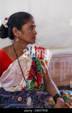 Portrait d'une jeune femme en vêtements traditionnels indiens assis dans une rue Goa Inde. Femme indienne d'âge moyen portant le saree. Photo de rue, éditorial Banque D'Images