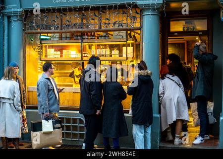 Des gens faisant la queue devant un magasin d'alimentation à Cambridge au Royaume-Uni Banque D'Images