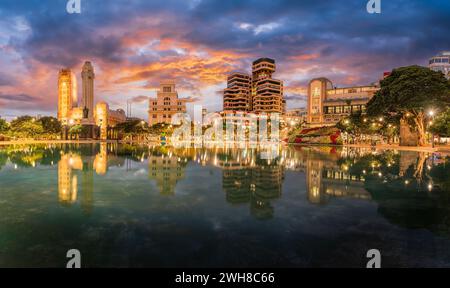 Le crépuscule descend sur la Plaza de España, Santa Cruz de Tenerife, avec des reflets époustouflants et des lumières de la ville créant une scène urbaine captivante. Banque D'Images