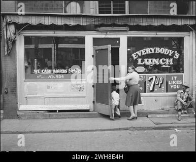 24 août 1946. Welch, comté de McDowell, Virginie-occidentale. Dame avec enfants entrant dans le restaurant "Everybody's Lunch". Welch est le centre commercial et de divertissement pour les camps miniers à proximité. Banque D'Images