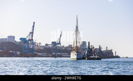 Un grand voilier amarré devant de grandes grues dans le port de fret de Valparaiso au Chili. Banque D'Images