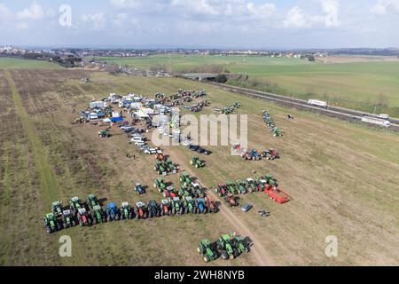 (NOTE DE LA RÉDACTION : image prise avec un drone)une vue aérienne d'un convoi de tracteurs stationnés dans un champ près de la GRA (périphérique) de Rome en périphérie de Rome attendant d'entrer dans la ville dans le cadre d'une protestation des agriculteurs italiens pour faire pression sur le gouvernement pour améliorer leurs conditions de travail. L’Italie est l’un des nombreux pays européens où les agriculteurs ont organisé des semaines de manifestations pour exiger une réduction des taxes sur les carburants, de meilleurs prix pour leurs produits et un assouplissement des réglementations environnementales de l’UE qui rendent plus difficile la concurrence avec des produits étrangers moins chers. Banque D'Images