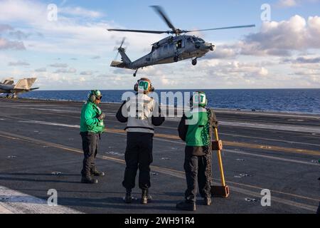 240206-N-LM220-2285 OCÉAN PACIFIQUE (6 février 2024) des marins se préparent à caler et à chaîner un hélicoptère MH-60S Sea Hawk, affecté au 14e Escadron de combat maritime (HSC), sur le pont d'envol du porte-avions USS Abraham Lincoln de classe Nimitz (CVN 72). Le Abraham Lincoln Carrier Strike Group est en cours dans la zone d'opérations de la 3rd Fleet des États-Unis menant une formation tactique avancée qui augmente la capacité de combat et les compétences tactiques dans tous les domaines. (Photo de l'US Navy par Clayton A. Wren, spécialiste des communications de masse, 2e classe) Banque D'Images