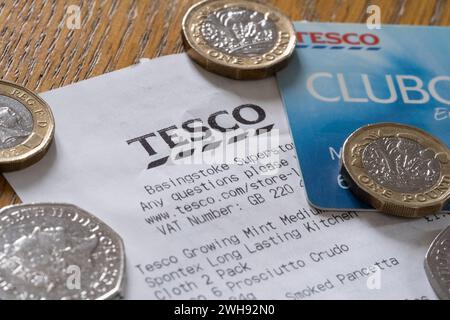 Reçu Tesco montrant la marque et le logo Tesco avec une Clubcard Tesco et des pièces. Thème : coût de la vie, inflation des prix, programme de fidélisation Banque D'Images