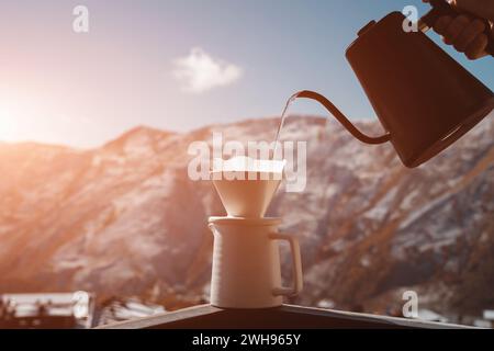 barista verse le café filtre dans une tasse avec une bouilloire à l'extérieur dans la nature Banque D'Images