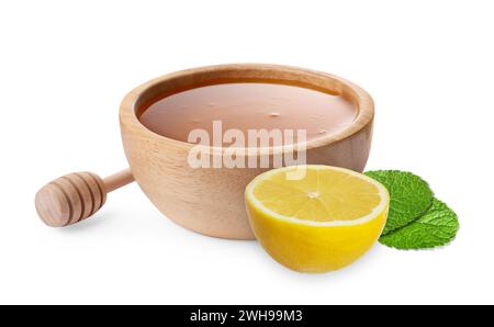 Miel dans un bol en bois, trempette et citron isolé sur blanc Banque D'Images