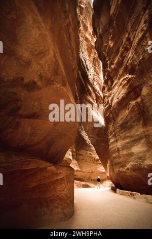 Touriste sur le Siq, le canyon étroit qui sert de passage d'entrée à la ville cachée de Petra, Jordanie Banque D'Images