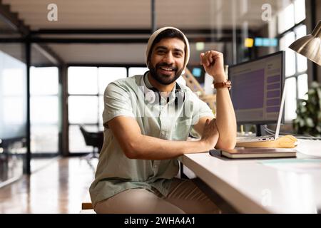 L'homme asiatique respire la confiance à son bureau dans un bureau moderne et décontracté. Banque D'Images