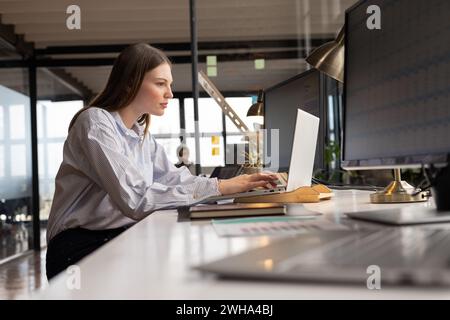 Jeune femme caucasienne travaille avec diligence à son bureau d'affaires décontracté Banque D'Images
