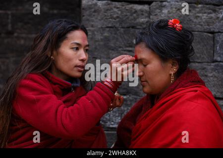 Népal s dangereux mois long Swosthani Brata Un dévot hindou népalais subissant un mois long Swosthani Brata applique de la poudre de vermillon sur le front d'un collègue rapide tout en étant assis le long de la rivière Bagmati le 9 février 2024. Les dévots hindous népalais subissent un jeûne ardu exécutant des rituels de Swasthani basés sur le Swasthani Brata Katha une écriture hindoue népalaise adorant la déesse Swasthani qui est apaisée est censée accorder le souhait des dévots. Les dévots du jeûne voyagent à divers endroits à l'intérieur et à l'extérieur de la vallée de Katmandou en visitant les sites religieux. Copyright : xSubashxS Banque D'Images