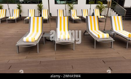 Chaises longues ou chaises longues disposées soigneusement sur une terrasse. Banque D'Images