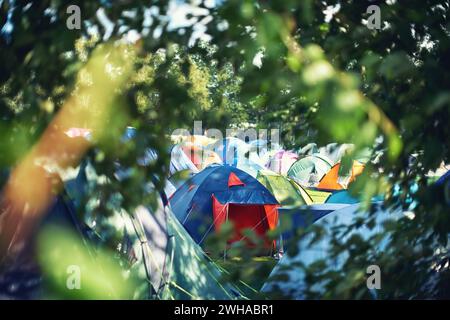 Nombreuses tentes, camping et plein air dans la nature pour un festival de musique. Rangée de chapiteaux arc-en-ciel placés sur le sol lors d'une soirée musicale, d'un événement de divertissement et Banque D'Images