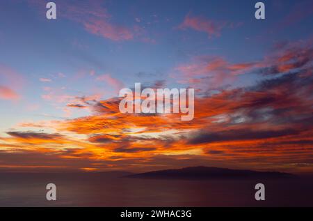 coucher de soleil spectaculaire avec des nuages rouges et oranges comme coups de pinceau dans le ciel bleu. spectacle de la nature. le ciel en flammes Banque D'Images