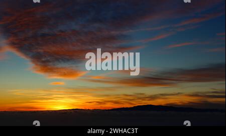 coucher de soleil spectaculaire avec des nuages rouges et oranges comme coups de pinceau dans le ciel bleu. spectacle de la nature. le ciel en flammes Banque D'Images