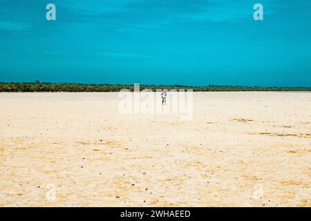 Un touriste marchant sur la plage de sable de Mida Creek à marée basse à Watamu, Malindi, Kenya Banque D'Images