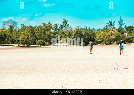 Un homme et une femme marchant sur la plage de sable de Mida Creek pendant la marée basse à Watamu, Malindi, Kenya Banque D'Images