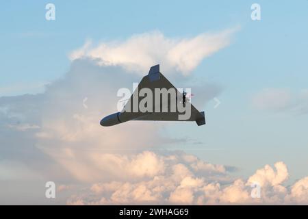 Un drone de combat kamikaze vole contre le ciel et les nuages, attaque et ciblage UAV, guerre en Ukraine et en Russie. Banque D'Images