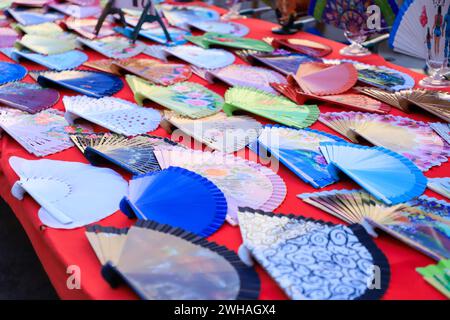 Une table avec des ventilateurs de main colorés Banque D'Images